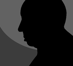 A grey background with the shadow of a man in black with a bald head